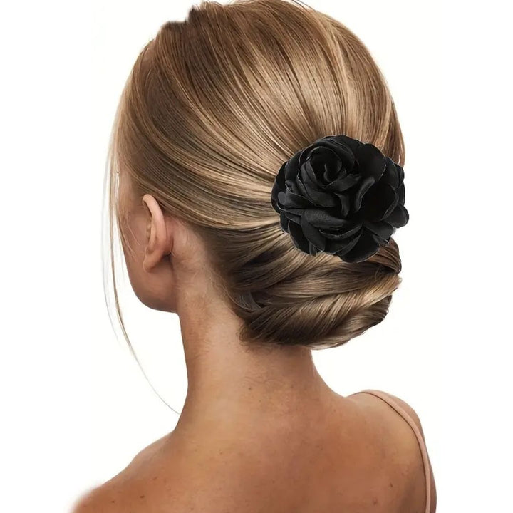 Frau mit elegantem Dutt und schwarzer Haarblume, Hochsteckfrisur, Brautfrisur, Haaraccessoire.