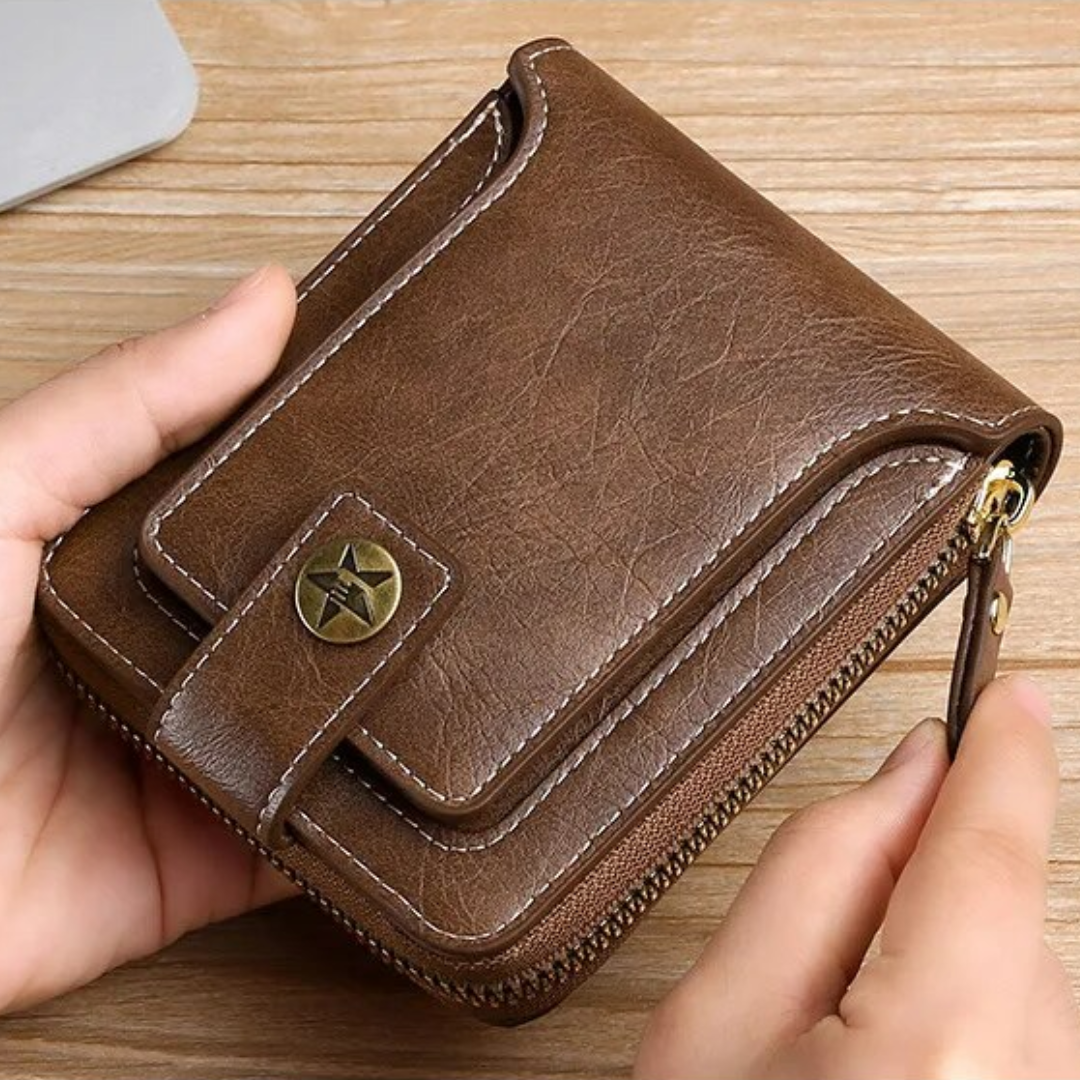 Braune Vintage-Leder-Geldbörse mit Reißverschluss und Sternknopf auf Holztisch.