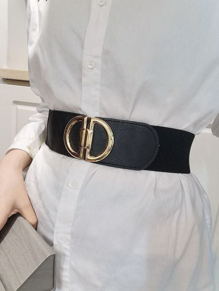 Schwarzer Vintage-Gürtel mit breitem elastischem Band und goldener Schnalle auf weißem Hemd.