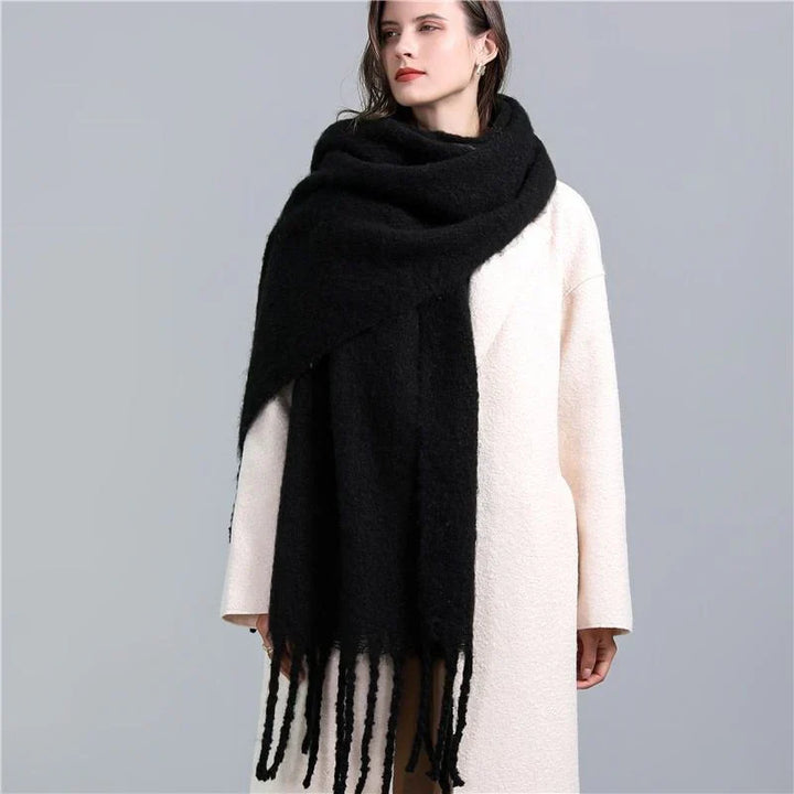 Frau mit schwarzem Wollschal und weißem Mantel, modisches Winteroutfit, elegant und warm.