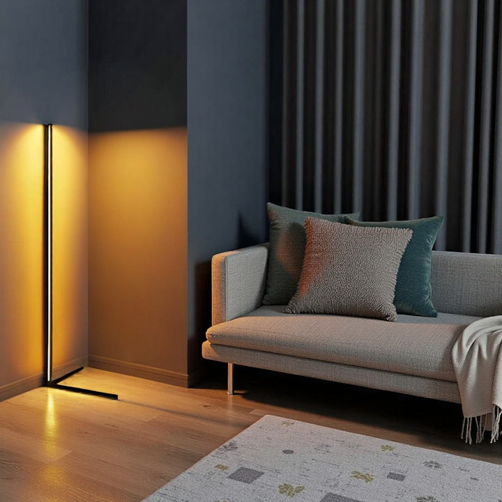 Lampa s oranžovým světlem v rohu obýváku vedle šedé pohovky s polštáři a vzorovaného koberce 11