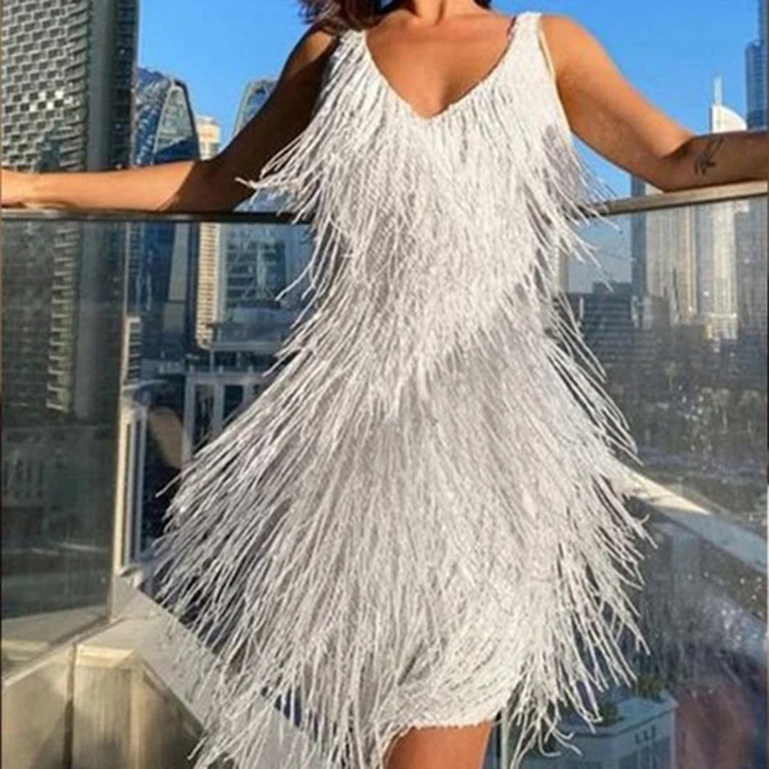 Frau in weißem Fransen-Kleid auf Balkon mit Stadtblick, elegantes Abendkleid, Sommermode.
