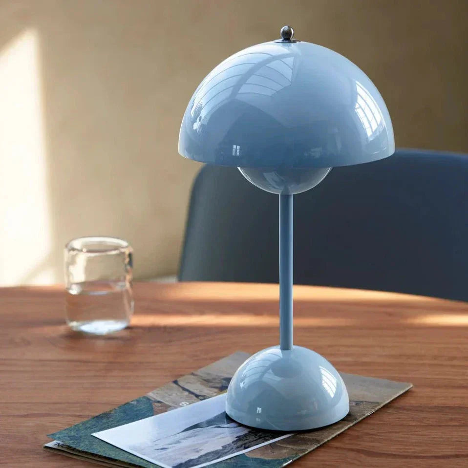 Blaue Tischlampe aus Metall auf Holztisch, modernes Design, skandinavische Inneneinrichtung.