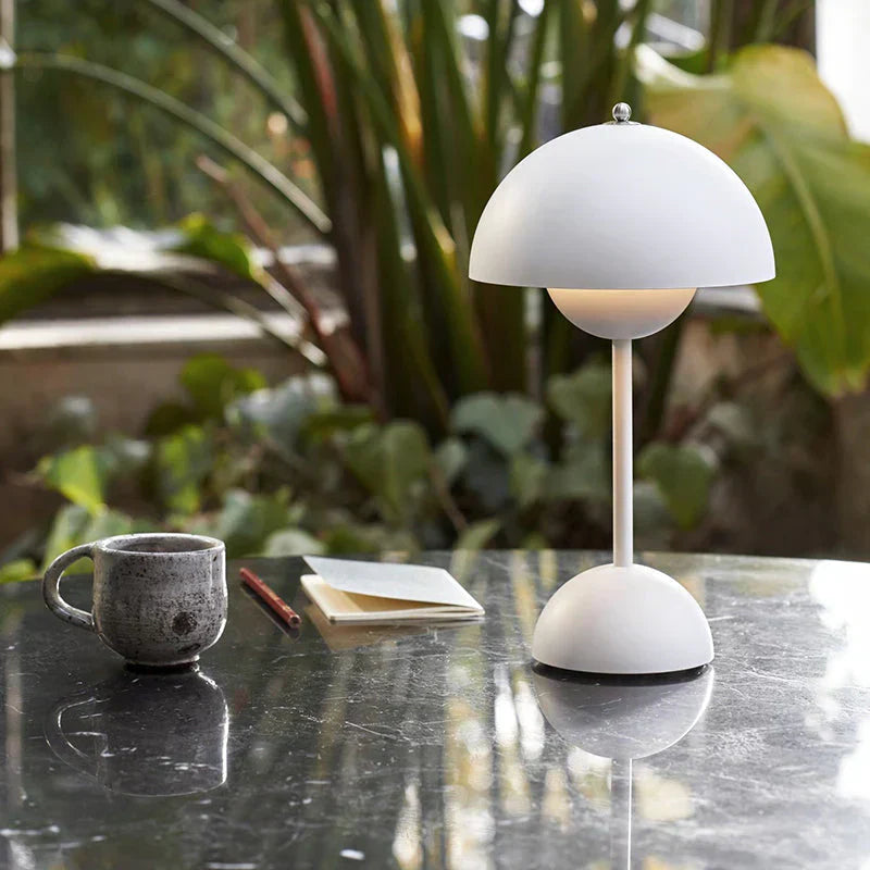Weiße Tischlampe aus Metall, modern, auf Marmortisch mit Tasse und Notizbuch, Innenraum.