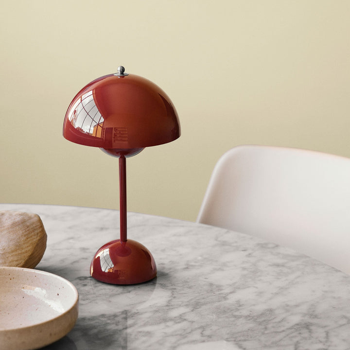 Weinrote Tischlampe aus Metall auf Marmortisch, modernes Design, Inneneinrichtung.