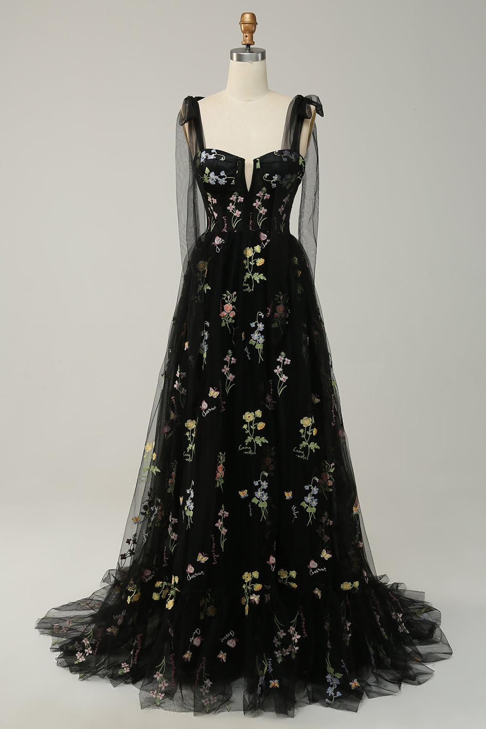 Schwarzes Abendkleid mit Blumenstickerei, Tüllträgern und Herzausschnitt auf Schneiderpuppe.