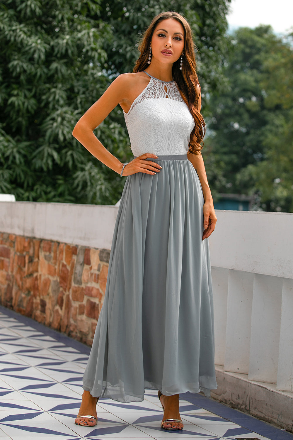 Frau in weißem Spitzenoberteil und grauem Maxirock, elegantes Sommeroutfit, draußen.