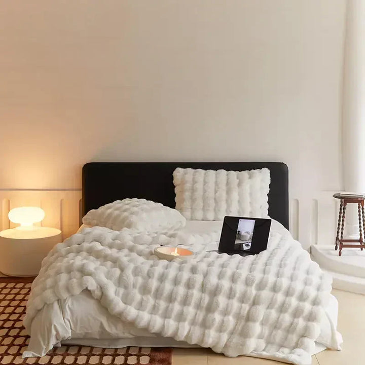 Weiche weiße Toscana Kaninchenfelldecke mit doppelseitigem Bubble-Fleece auf Bett.