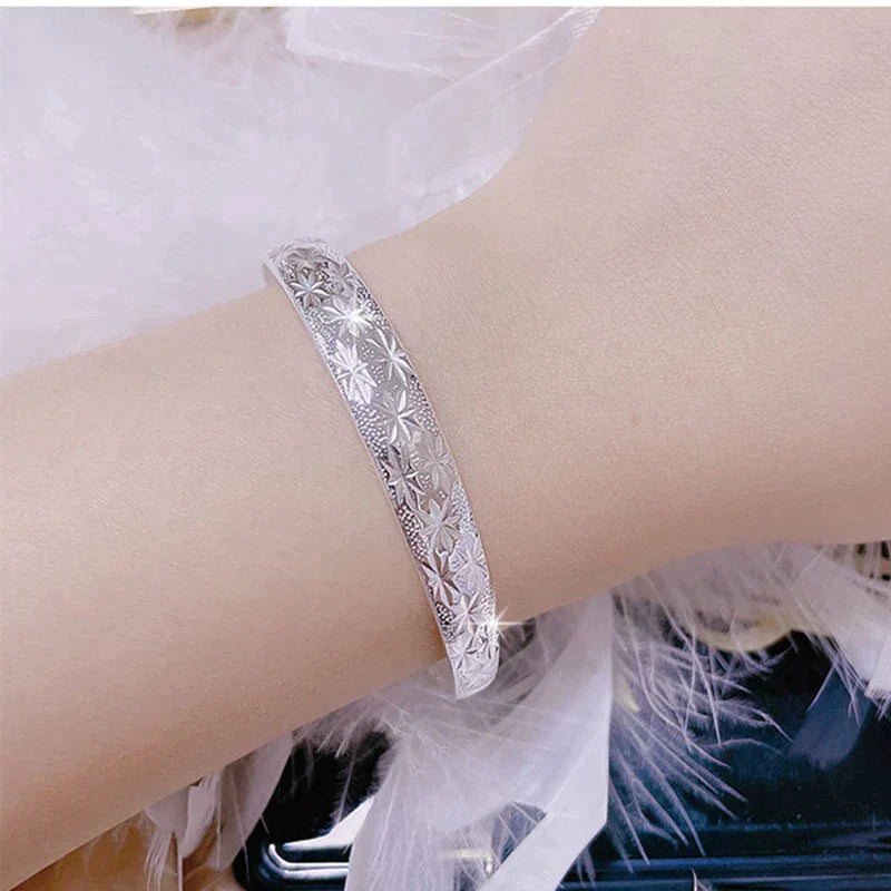 Silberne Damenarmband mit Sternenmuster, modisches Schmuckaccessoire, Geschenkidee.