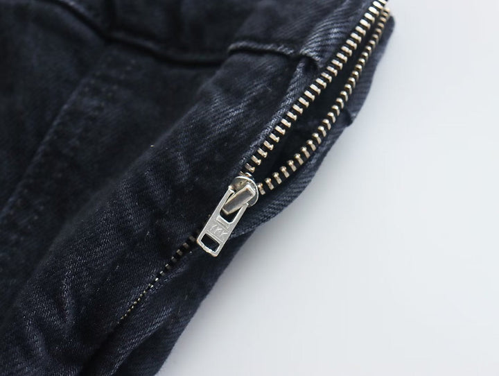 Schwarze Jeans mit silbernem Reißverschluss, Denim-Stoff, modisch, Detailaufnahme.
