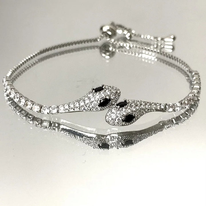 Silbernes Schlangenarmband mit Strasssteinen, verstellbar, elegantes Schmuckdesign.
