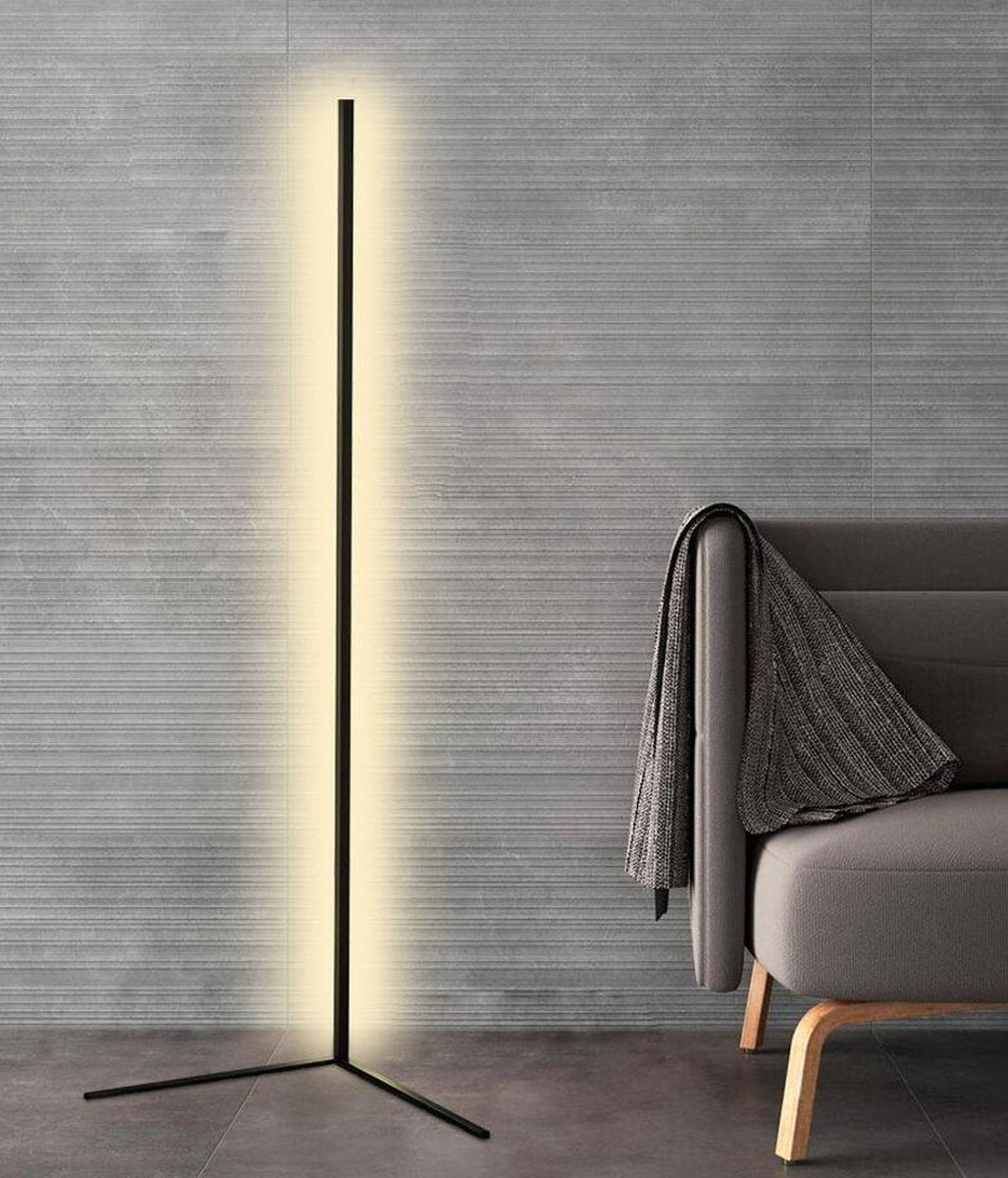 Lampa s dvěma rameny podstavce před šedou strukturovanou stěnou vedle křesla s přehozem 8