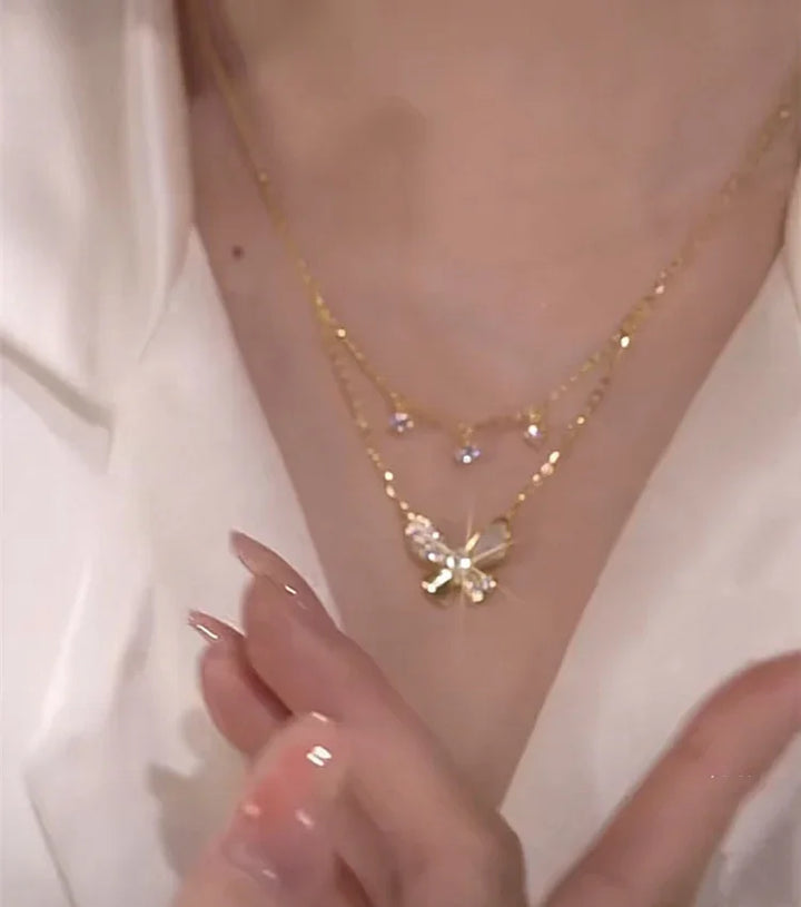 Goldene Schmetterlingskette mit Kristallen, eleganter Schmuck, Damenmode, Nahaufnahme.
