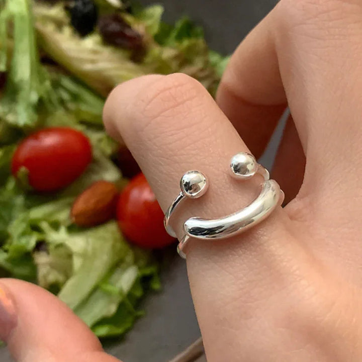 Silberner verstellbarer Ring mit Kugeldetails auf Hand, modisches Schmuckdesign.