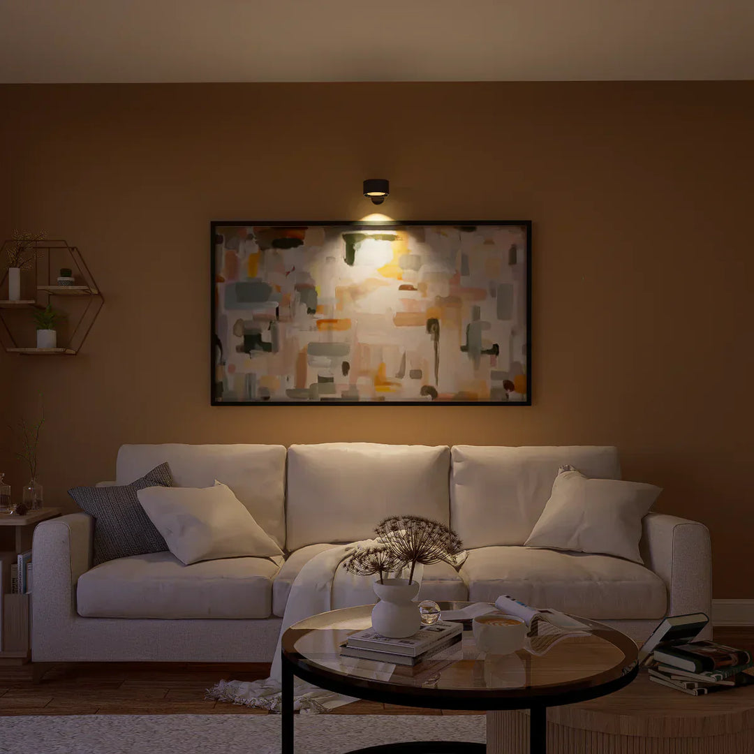 Beige Sofa mit Kissen, abstraktes Gemälde an brauner Wand, moderne Wohnzimmerdekoration.