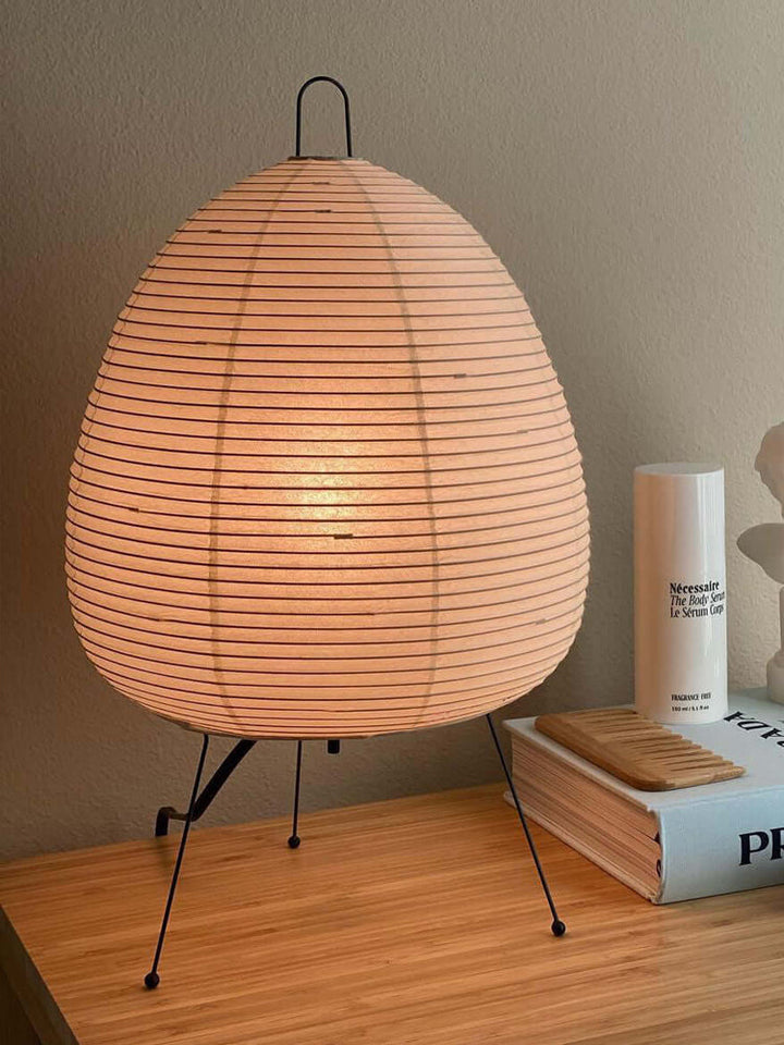 Akari Tischlampe aus Papier, beige, auf Holzoberfläche, modernes Design, Beleuchtung, Inneneinrichtung.