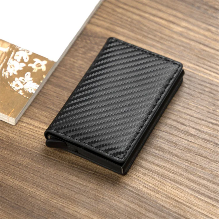 Schwarzer Aluminium-Geldklammer-Kartenhalter auf Holztisch, stilvolles Design.