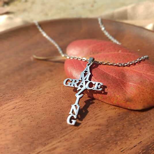 Silberne "Amazing Grace" Kreuzkette auf braunem Blatt, Schmuck, Geschenkideen, religiös.