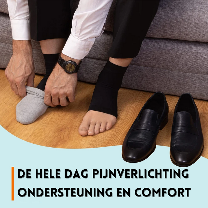 Mann zieht schwarze Kompressionssocken an, Lederschuhe, Holzboden, Schmerzlinderung.