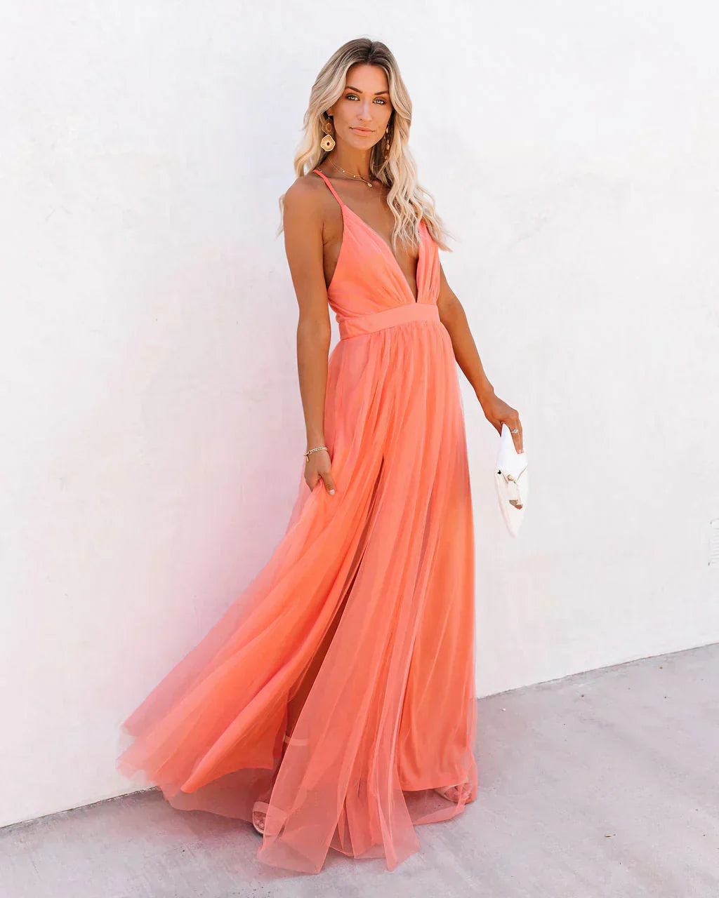 Frau in apricotfarbenem Maxikleid, ärmellos, fließend, elegantes Abendkleid, Sommermode.
