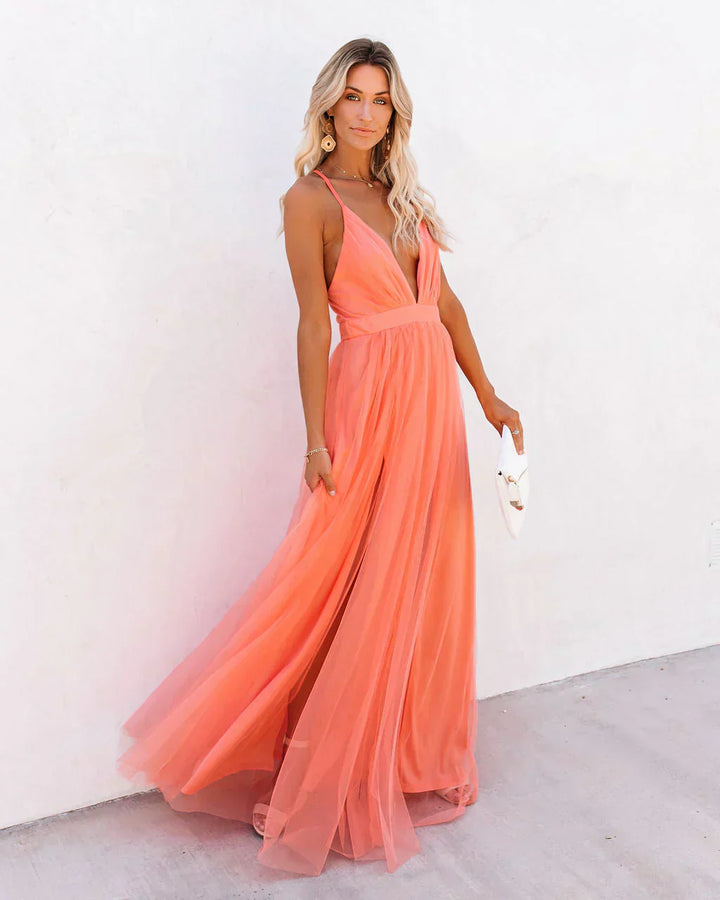 Frau in apricotfarbenem Maxikleid, ärmellos, fließend, elegantes Abendkleid, Sommermode.