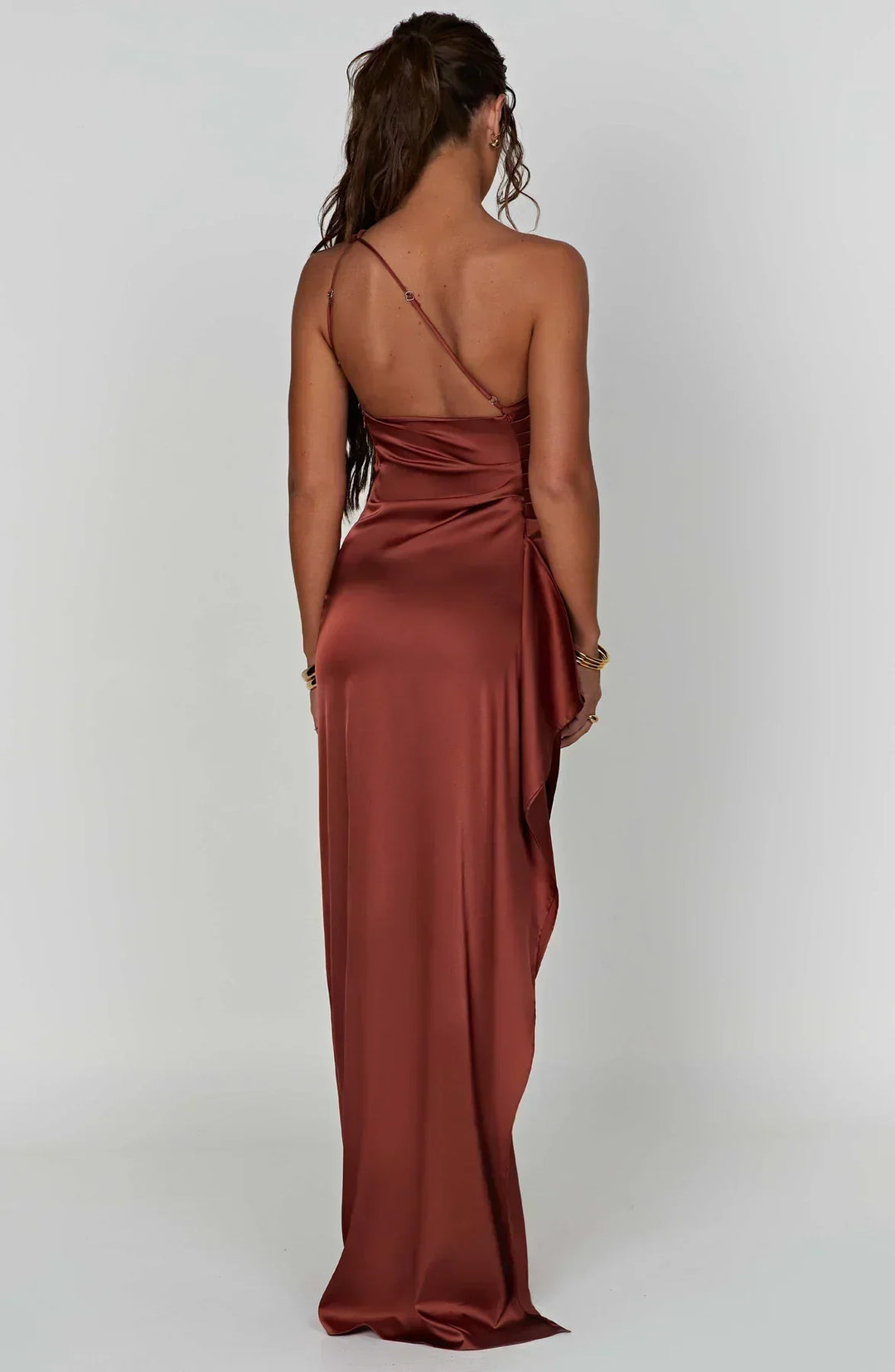Frau in rostfarbenem Satin-Maxikleid mit Spaghettiträgern, elegantes Abendmode-Outfit.