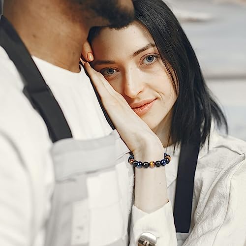 Frau mit blauem Perlenarmband, lehnt an Mann in weißer Kleidung, Nahaufnahme, modisch.
