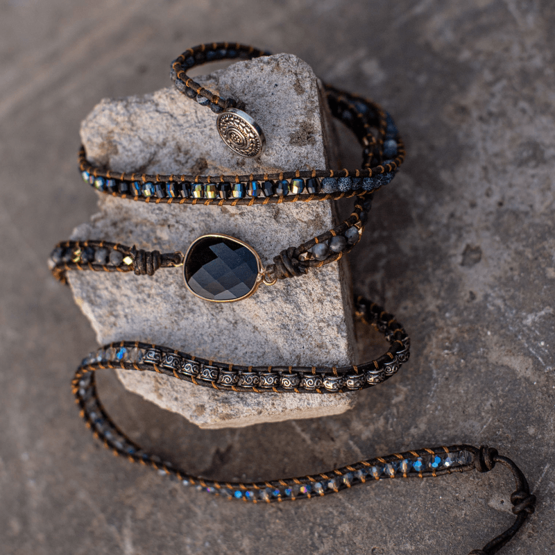 Handgefertigtes Armband mit schwarzem Onyx, Lederband, goldenen und blauen Perlen.