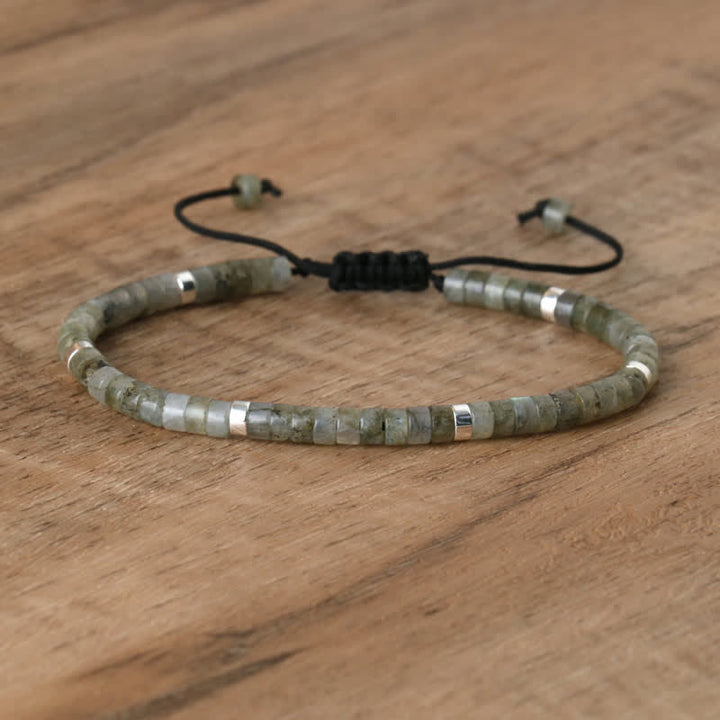 Armband aus grünem Labradorit mit verstellbarem Verschluss auf Holzoberfläche.