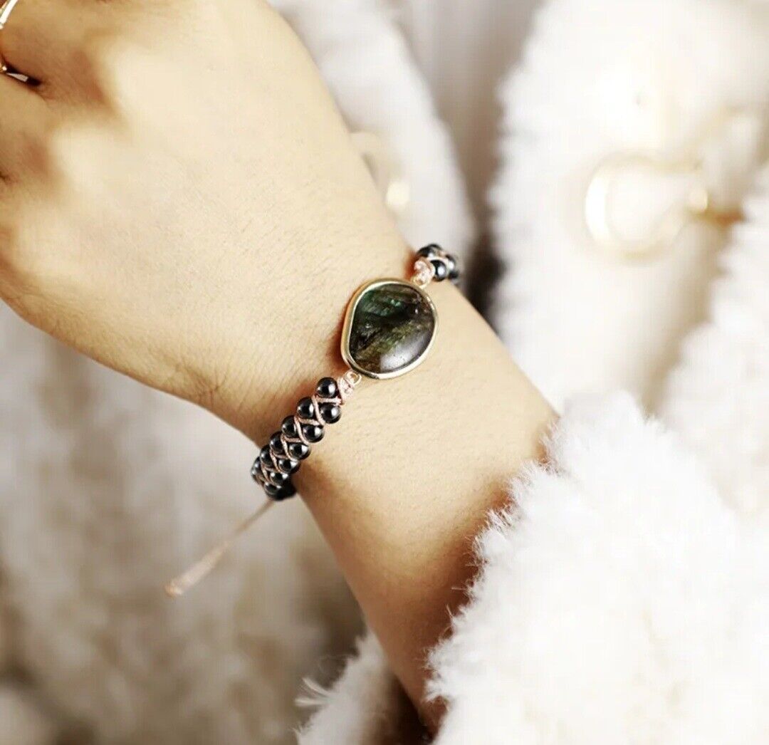 Damenarmband mit grünem Edelstein und schwarzen Perlen, elegantes Schmuckdesign.