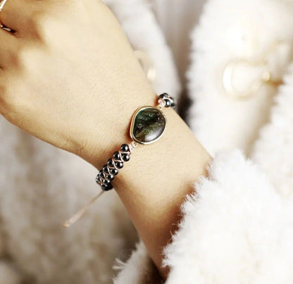 Damenarmband mit grünem Edelstein und schwarzen Perlen, elegantes Schmuckdesign.