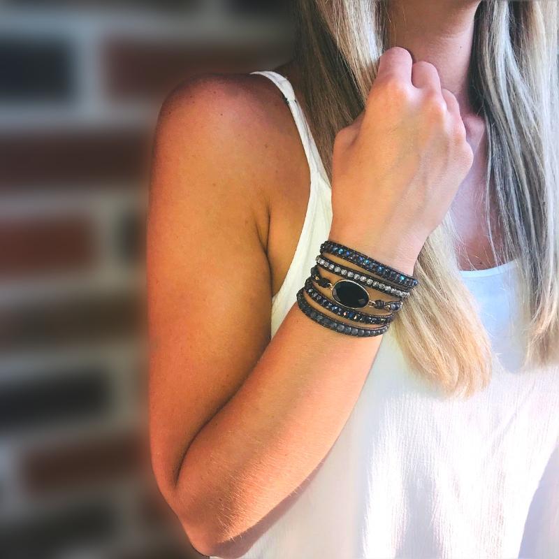 Frau mit Onyx-Armband, schwarzer Schmuck, Lederarmband, modisches Accessoire, Damenmode.