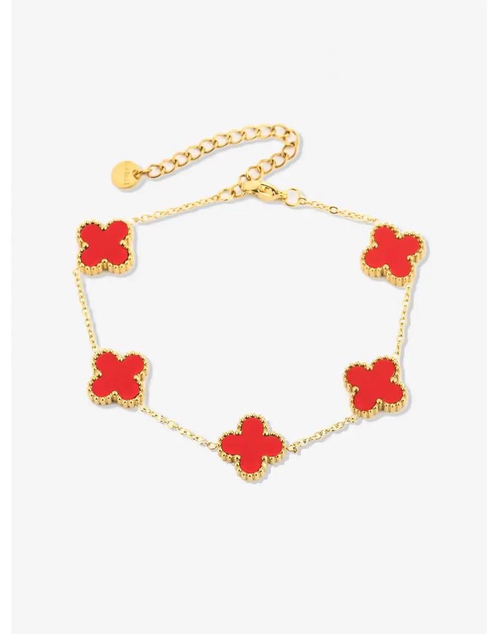 Goldenes Armband mit roten Kleeblatt-Anhängern, elegantes Schmuckdesign, Damenaccessoire.