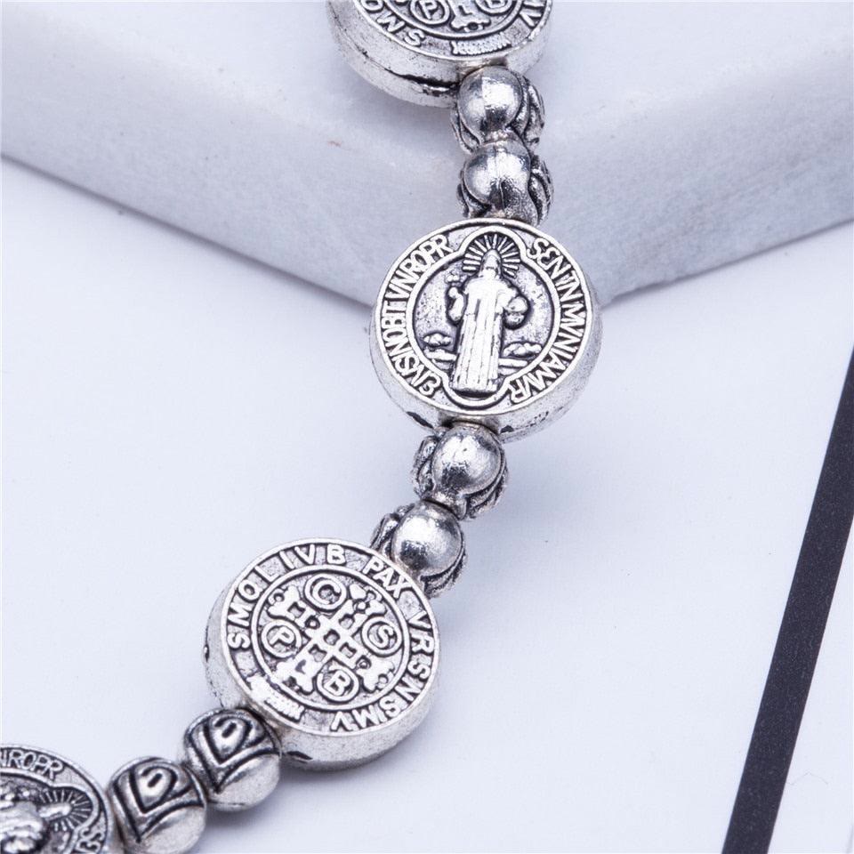 Silbernes Armband mit Benediktus-Medaillen, religiöser Schmuck, detailreich graviert.