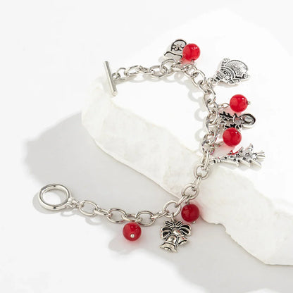 Silbernes Charm-Armband mit roten Perlen und Anhängern auf weißem Hintergrund.