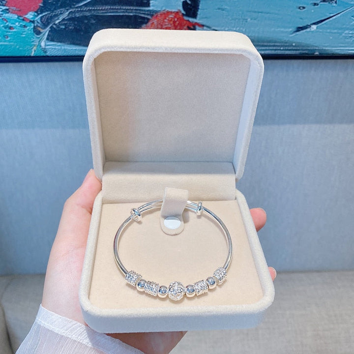 Silbernes Armband mit Perlen in beiger Schmuckschatulle, elegantes Design, Geschenkidee.