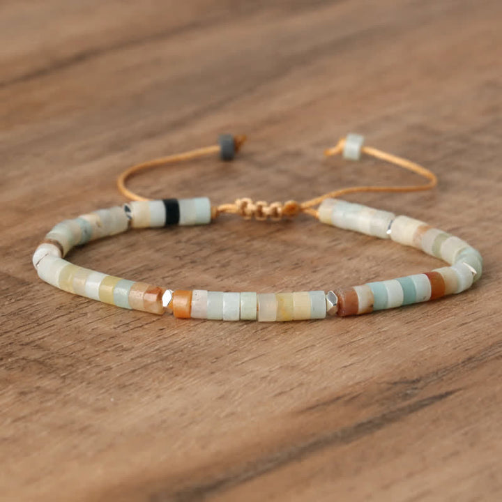 Armband aus bunten Edelsteinperlen auf Holzoberfläche, verstellbar, handgefertigt.