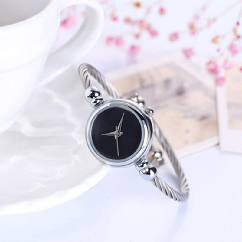 Silberne Damenarmbanduhr mit schwarzem Zifferblatt, elegantes Design, modisches Accessoire.