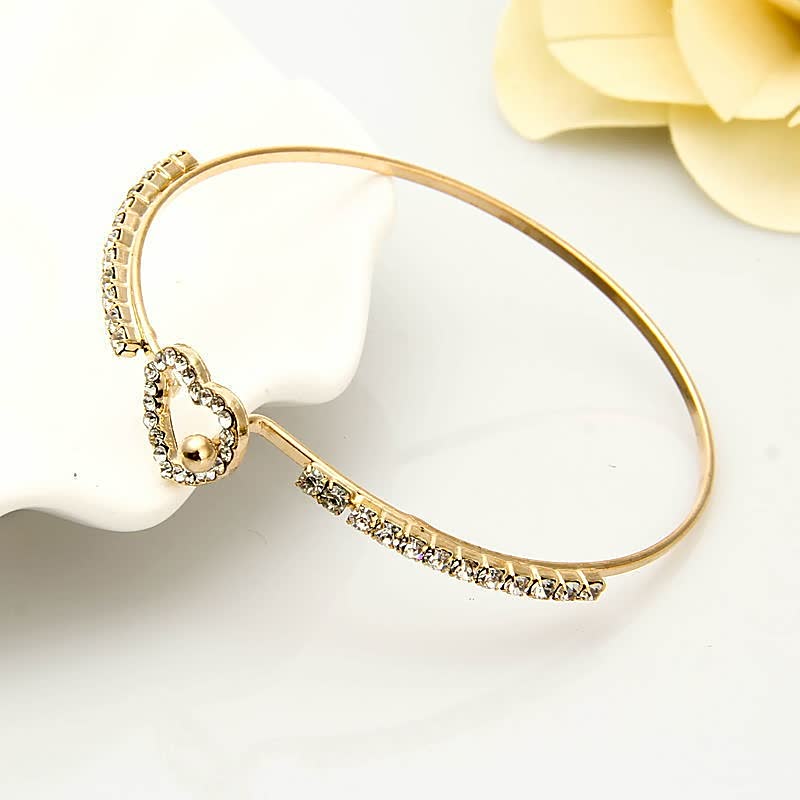 Goldenes Armband mit Herzanhänger und Strasssteinen, eleganter Schmuck für Damen.