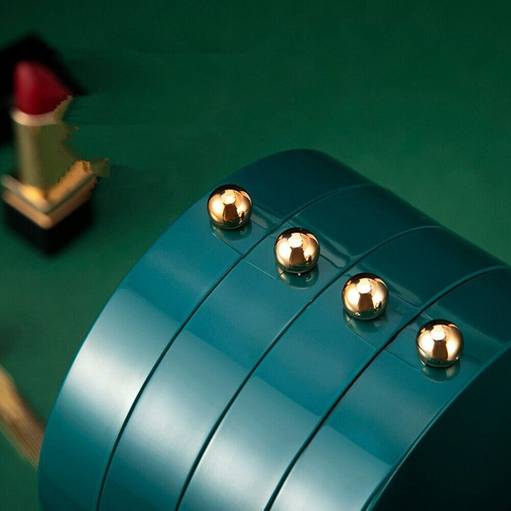 Grüner Schmuckkasten mit goldenen Knöpfen, luxuriöses Design, elegantes Aufbewahrungsaccessoire.