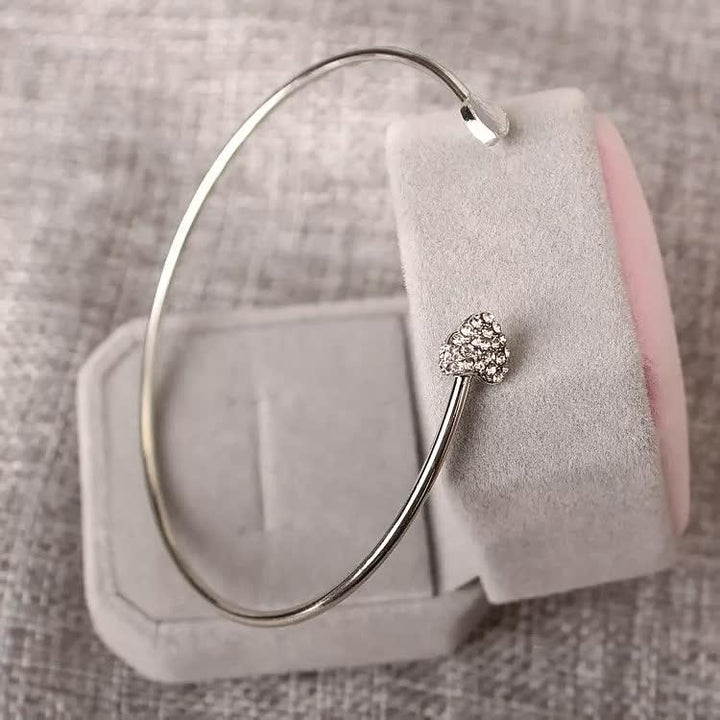 Silbernes Armreif mit Herzanhänger, Strasssteine, elegantes Schmuckdesign, Geschenkbox.