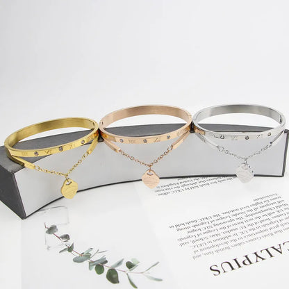 Drei Armreifen aus Edelstahl in Gold, Roségold und Silber mit Herzanhänger und Gravur.