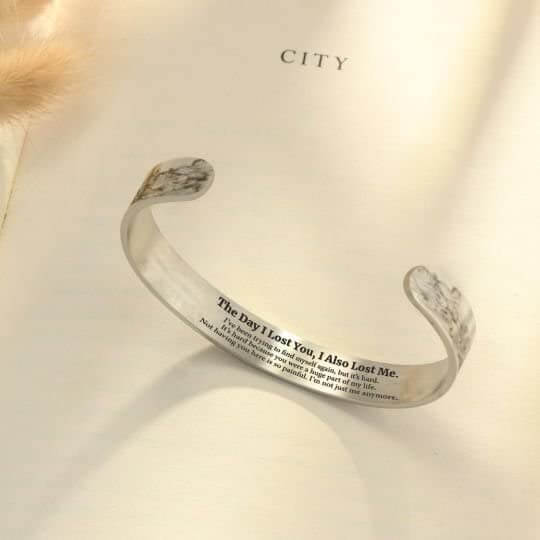 Silbernes Armband mit Gravur auf Buchseite, elegantes Schmuckstück, Geschenkidee für Frauen.