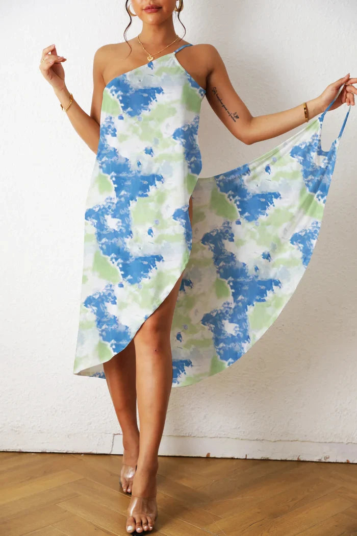 Frau in blau-grünem Batik-Kleid, asymmetrisch, ärmellos, Sommermode, Holzfußboden.