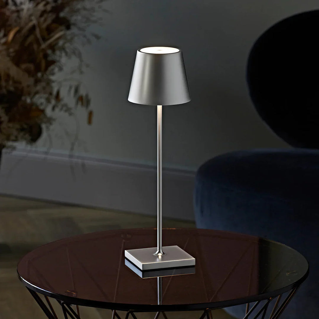 Moderne silberne Tischlampe auf Glastisch, minimalistisches Design, Wohnzimmerbeleuchtung.
