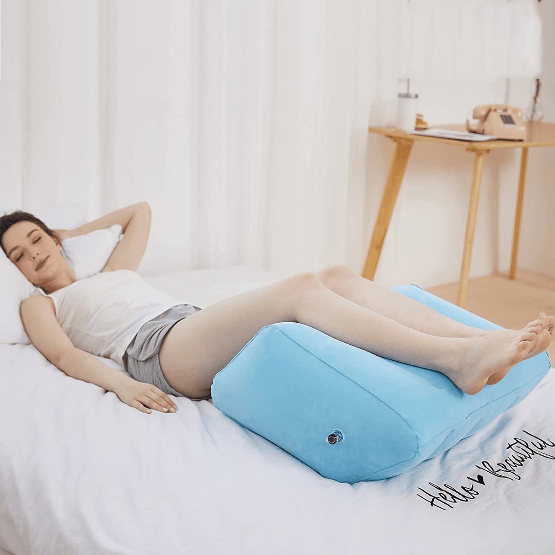 Frau entspannt auf blauem aufblasbarem Beinkissen, ideal für Beinunterstützung und Komfort.