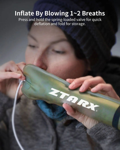 Person bläst aufblasbares ZTARX-Kissen auf, tragbares Camping-Zubehör, olivgrün.