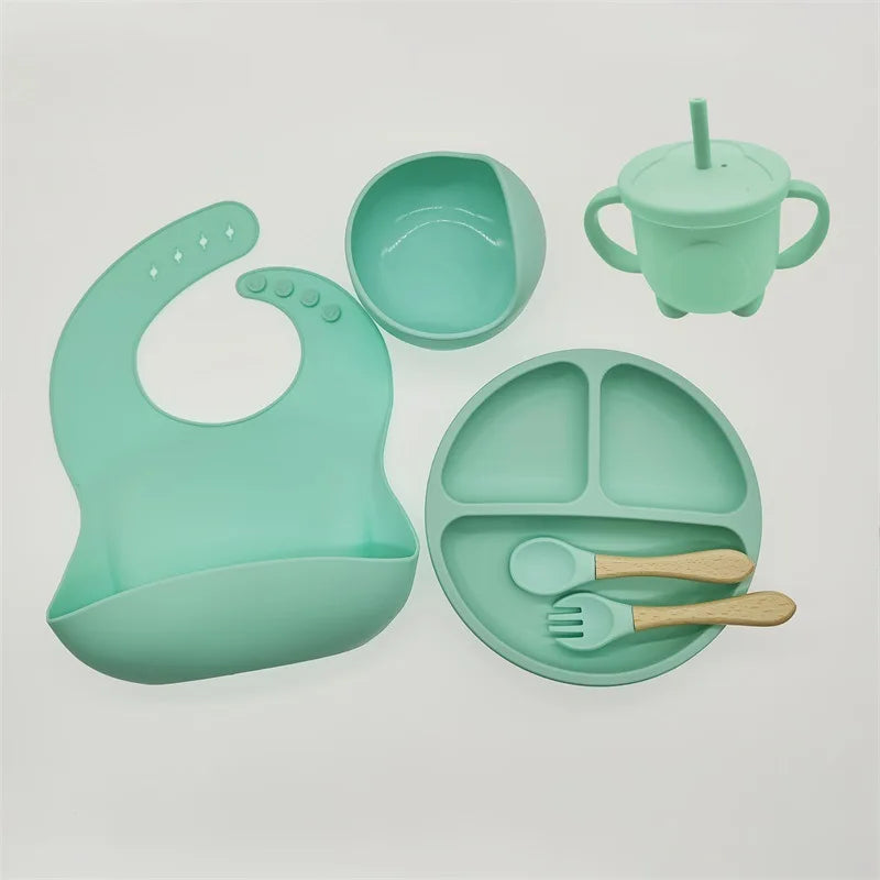 Mintgrünes Babygeschirr-Set aus Silikon mit Lätzchen, Teller, Becher und Besteck.