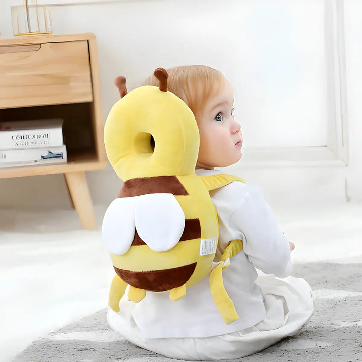 Kleinkind mit gelbem Bienen-Rückenschutzkissen, Sicherheitskissen für Babys, auf Teppich.
