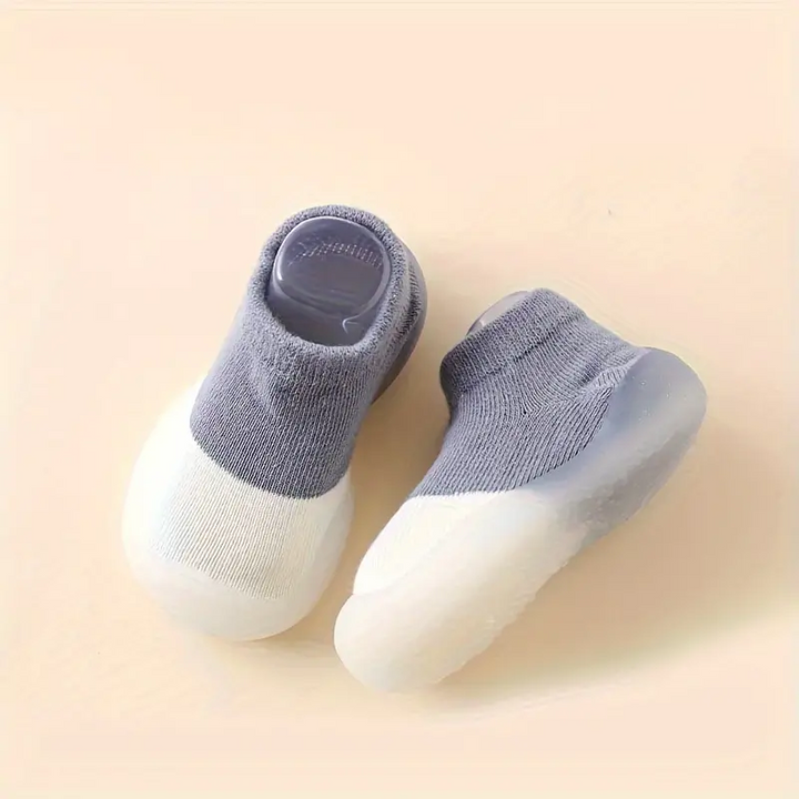 Graue Babyschuhe mit rutschfester Sohle, weiches Material, ideal für Kleinkinder.